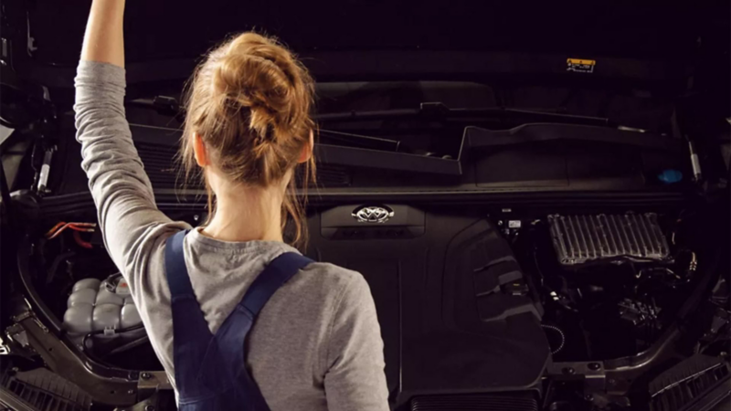 Técnica de Volkswagen abre cofre de una camioneta SUV para revisar motor. 