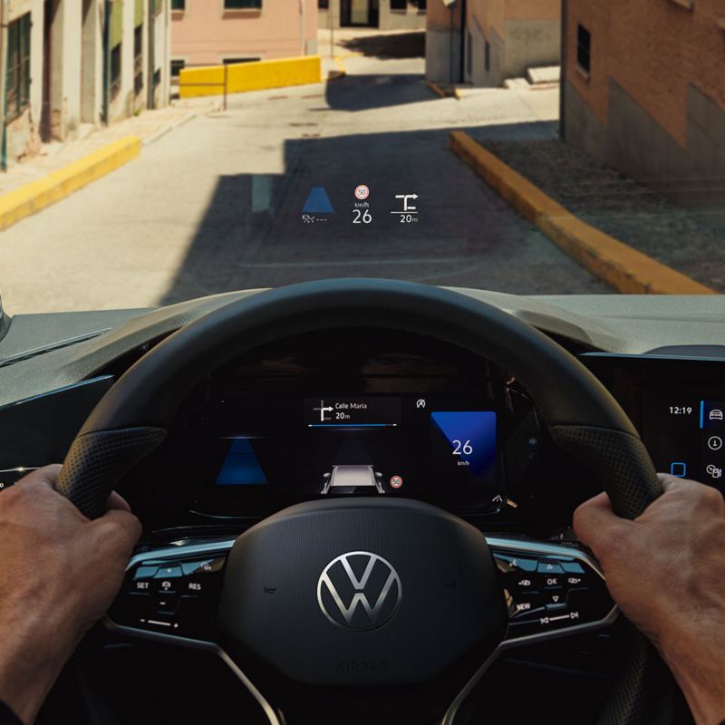 Vue à travers le pare-brise d'une VW Golf depuis la place conducteur, avec l'affichage tête haute activé.