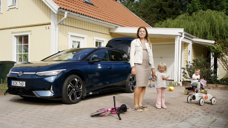 Berit med familjen står framför sin blåa ID.7 GTX Tourer