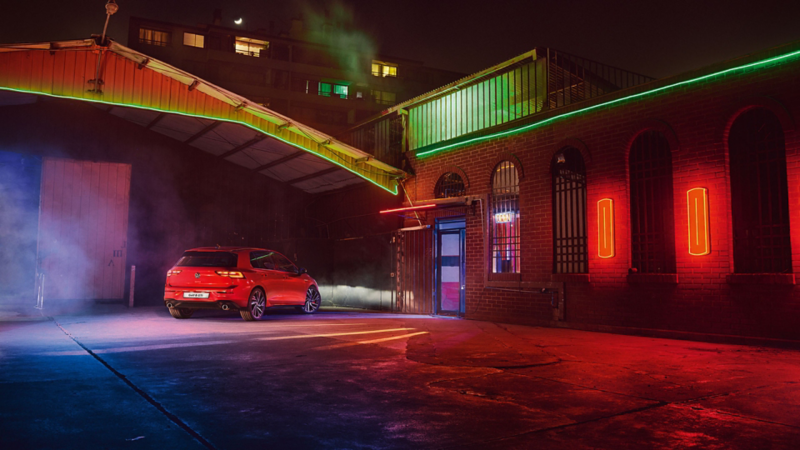 VW Golf GTI in red, rear view, parked in a warehouse