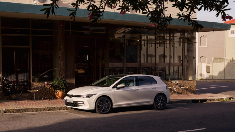 A white VW Golf parked outside a building