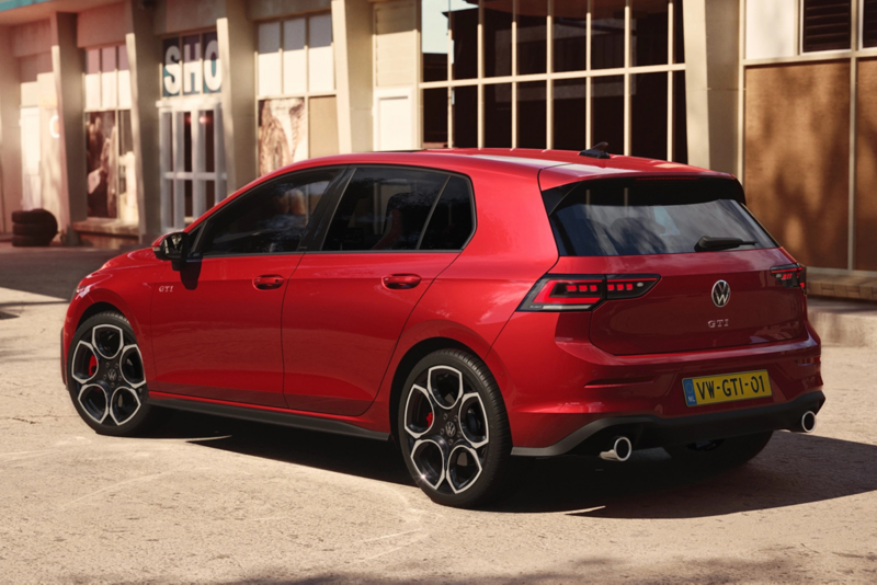 Schuin achteraanzicht van een rode Volkswagen Golf GTI die geparkeerd staat, het is vrij zonnig