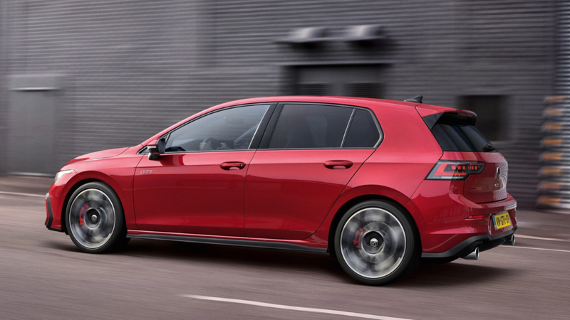 Zijaanzicht van een rode Volkswagen Golf GTI die rijdt op een weg