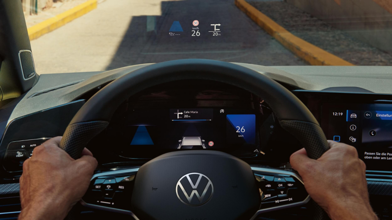 A close-up of a pair of hands on a steering wheel
