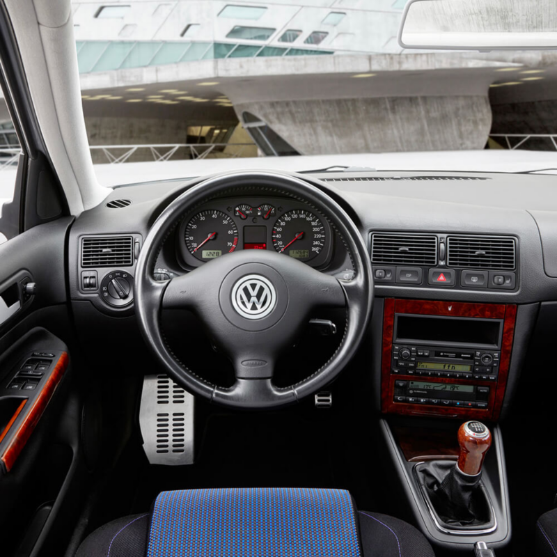 Intérieur d'un Golf Mk4 GTI avec des détails boisés rouges sur la console centrale.