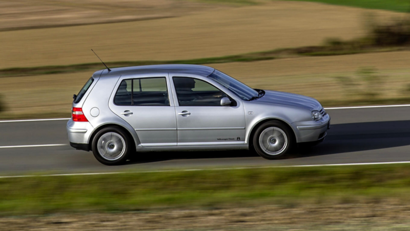 Golf Mk4 grise métallisée en circulation sur une route.