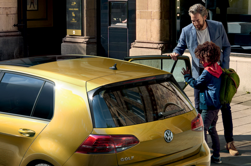 VW Golf parking on the street, family getting in