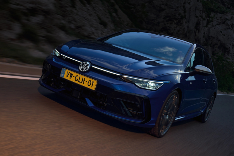 Schuin vooraanzicht van een blauwe Volkswagen Golf R die rijdt op de snelweg, het is vrij donker