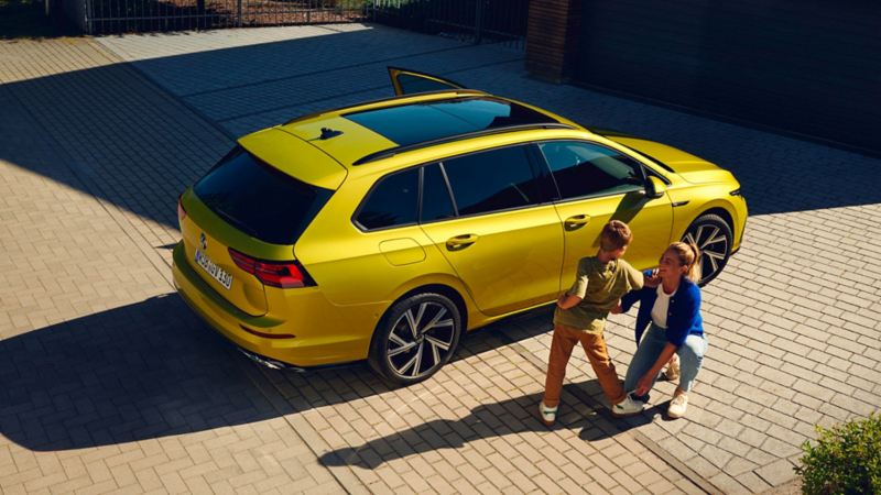 golf sw jaune avec une mère et son fils qui joue devant