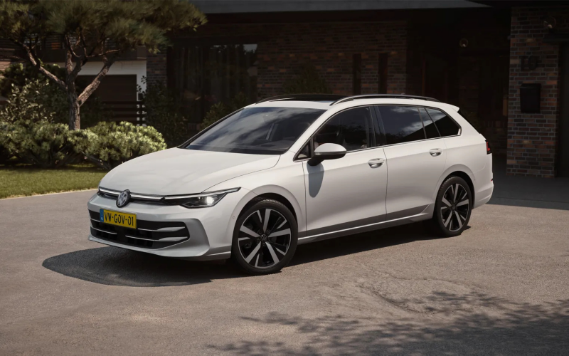 Schuin vooraanzicht van een witte Volkswagen Golf Variant die geparkeerd staat op een oprit