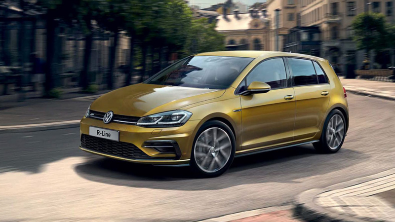 A yellow Volkswagen Golf R-Line (MK7) being driven on a city road