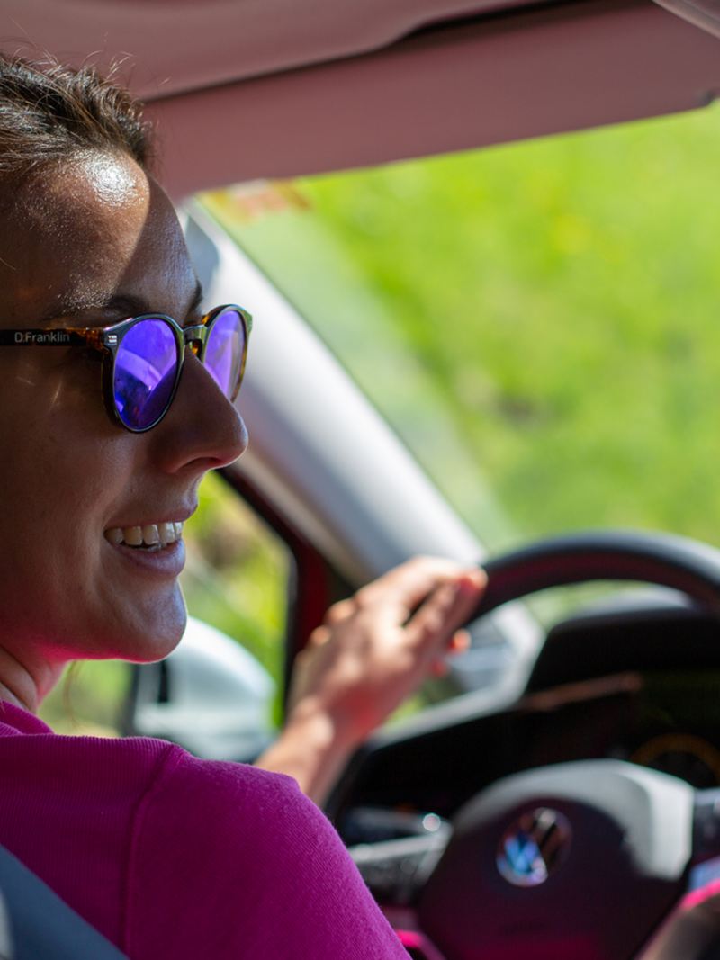 Una donna con gli occhiali da sole siede al volante della Golf Alltrack.