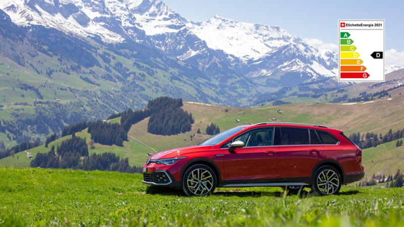 Golf Alltrack in piedi nel campo e le montagne sullo sfondo