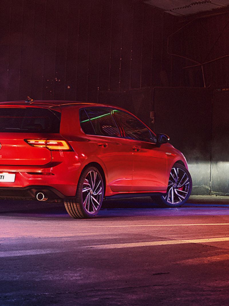 VW Golf GTI in red, rear view, parked in a warehouse
