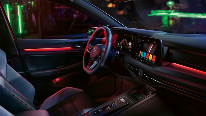 VW Golf GTI interior, cockpit view, woman operating infotainment system