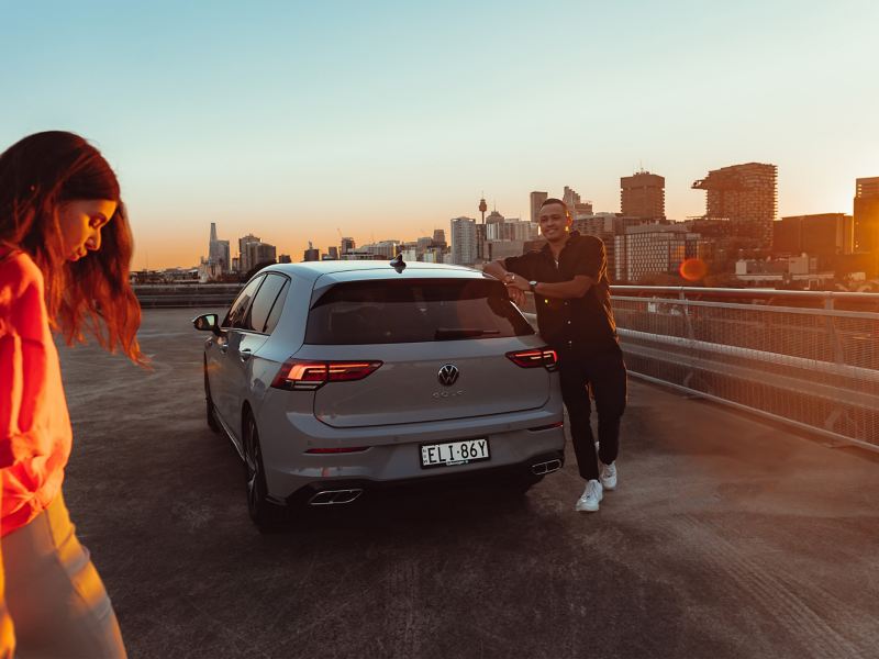 Rear angle of the couples around Volkswagen Golf parked on the roof.