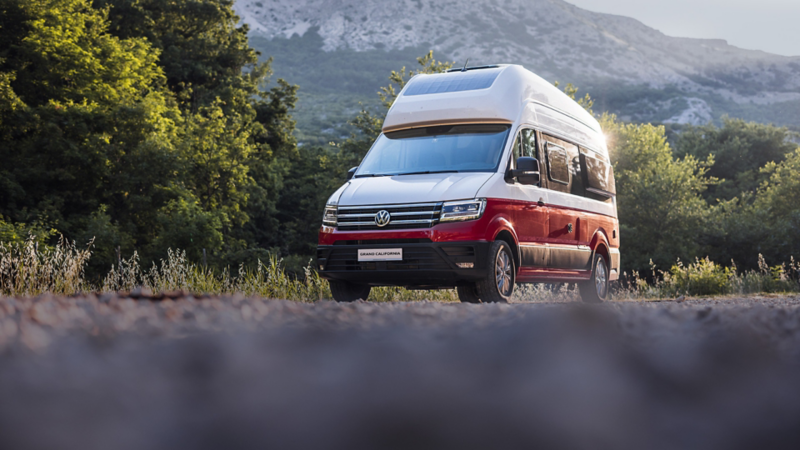 Volkswagen Grand California stoi na drodze w górach.