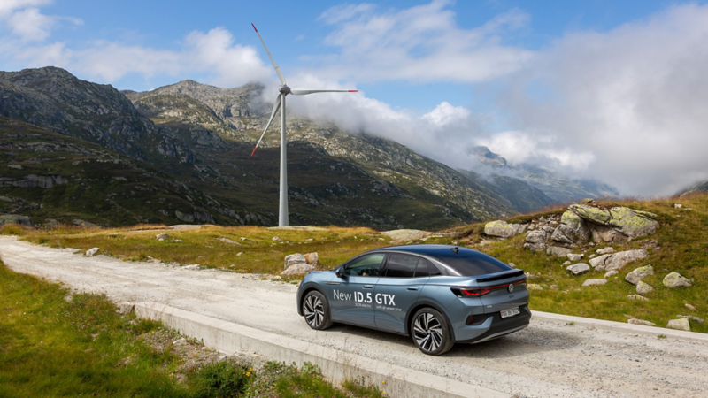 ID.5 GTX sur une route secondaire et derrière elle se trouve une éolienne