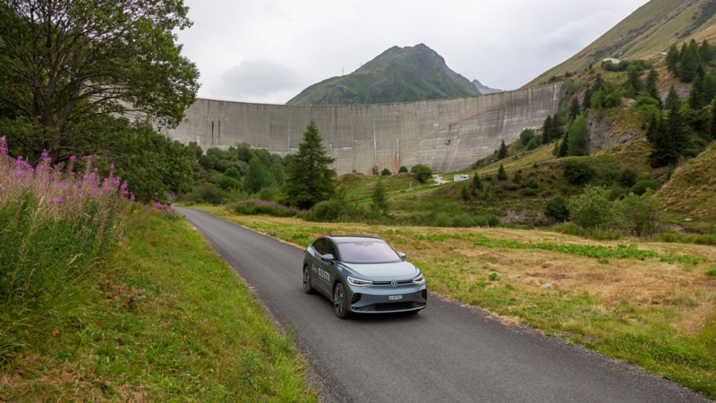ID.5 GTX roule sur une petite route secondaire et on voit un barrage à l'arrière-plan
