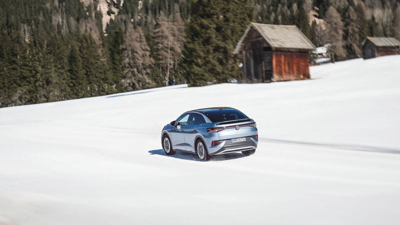 Un ID.5 roule sur un chemin recouvert de neige, dans un paysage montagnard.