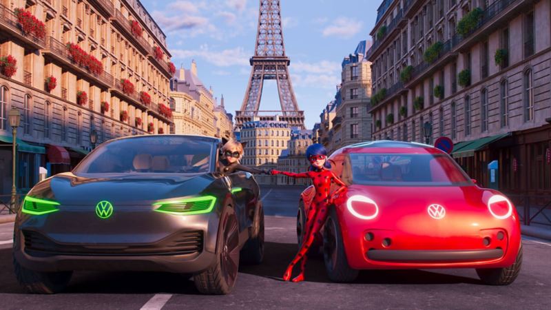 Devant la Tour Eiffel, Chat Noir dans son Volkswagen ID. Crozz, et Ladybug accoudée à sa Volkswagen New Electrique Beetle joignent leurs poings.