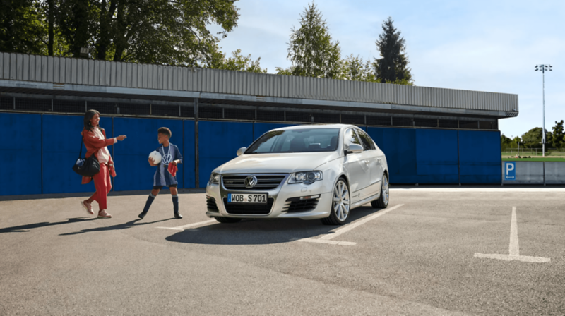 Kobieta i chłopiec obok bialego Passata B6 