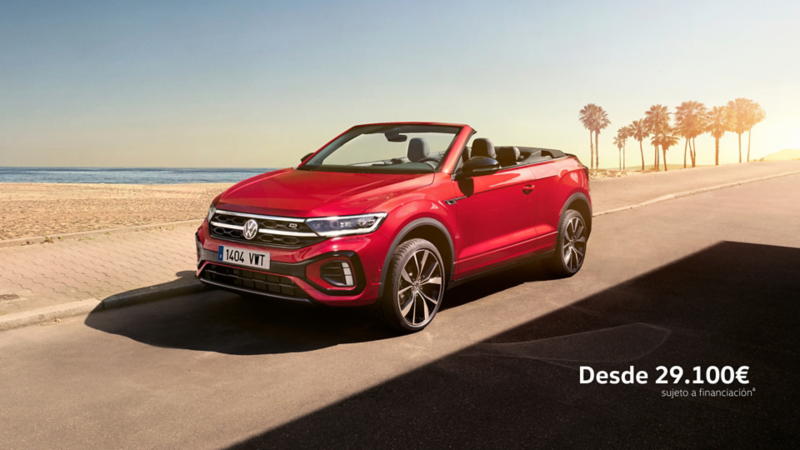 Un Volkswagen T-Roc Cabrio de color rojo estacionado al lado de una playa