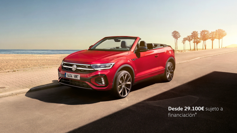 Un Volkswagen T-Roc Cabrio de color rojo estacionado al lado de una playa