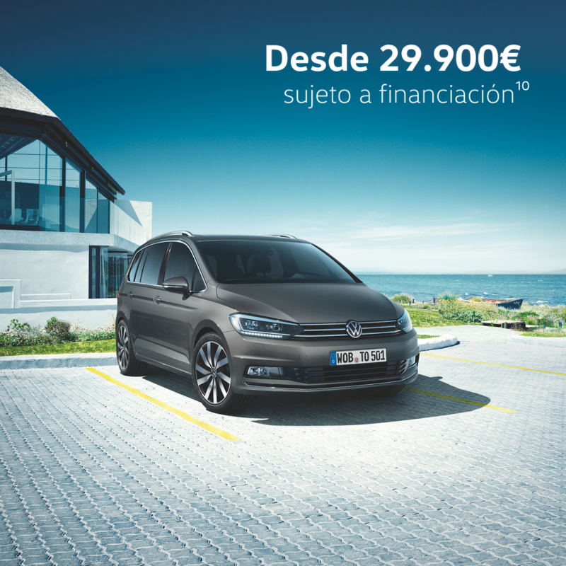 Un Volkswagen Touran de color gris estacionado fuera de una casa
