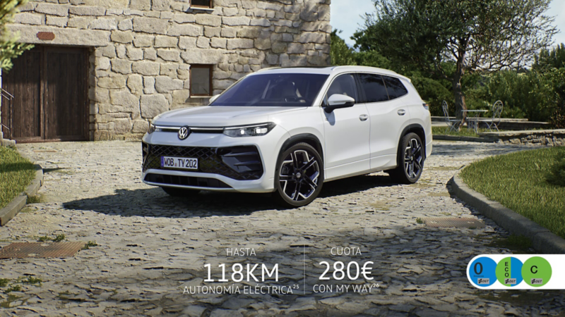 Un Volkswagen Tayron de color blanco estacionado delante de una casa