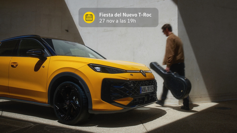 Un Volkswagen Nuevo T-Roc en primer plano y un chico por detras sosteniendo una guitarra
