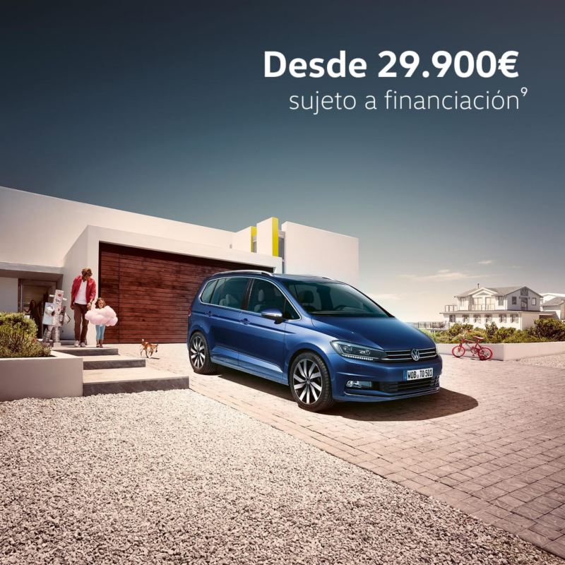 Un Volkswagen Touran de color gris estacionado fuera de una casa