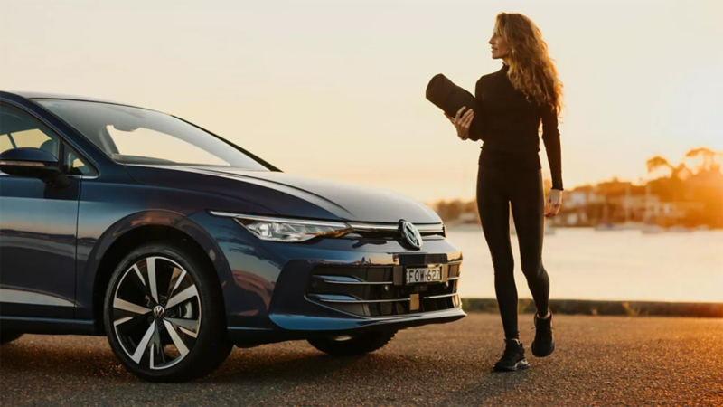 Woman standing in front of her VW golf