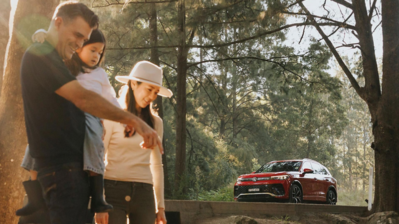 parents and child in the foreground with the new Tiguan in the background. 