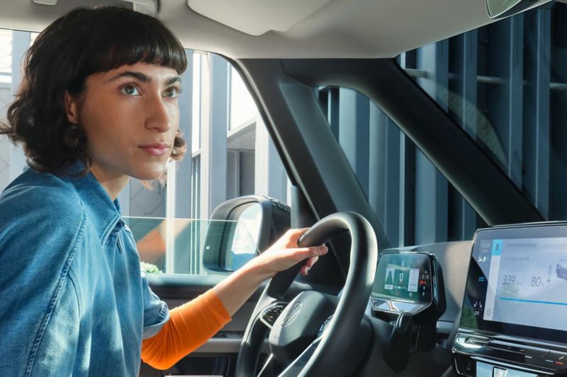 Eine Frau sitzt am Steuer eines VW.