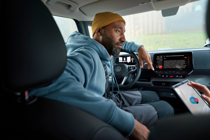 El VW Nuevo California aparcado en la orilla junto a dos personas.