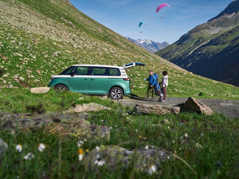 Vista laterale di Volkswagen ID. Buzz con  portellone posteriore aperto in montagna.