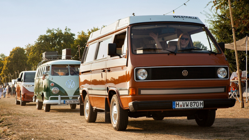 Plusieurs générations de VW Combi roulent les unes derrière les autres.