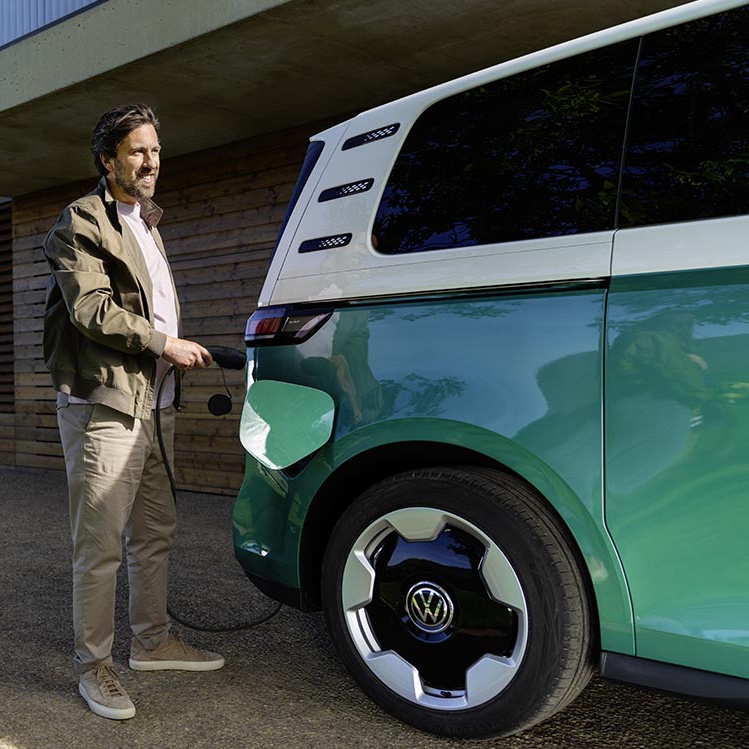 Un VW ID. Buzz aparcado junto a una estación de carga doméstica.