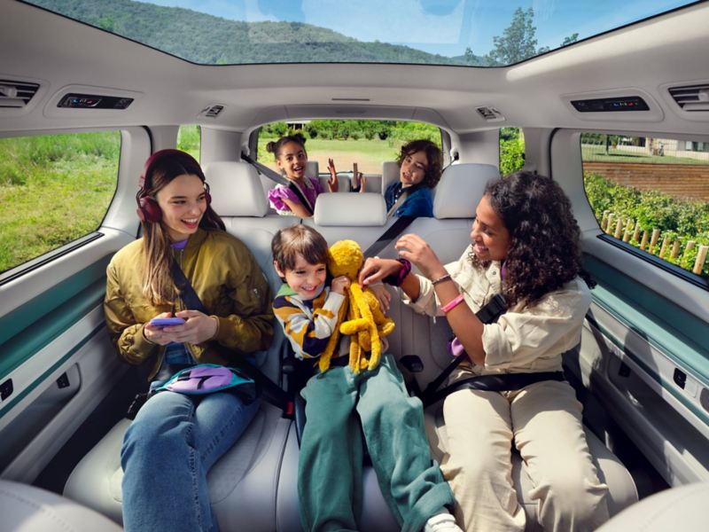 Fünf Kinder sitzen im Fond des VW ID. Buzz mit langem Radstand.