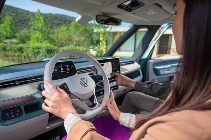 El VW Nuevo California aparcado en la orilla junto a dos personas.