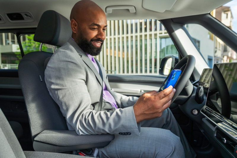 El VW Nuevo California aparcado en la orilla junto a dos personas.