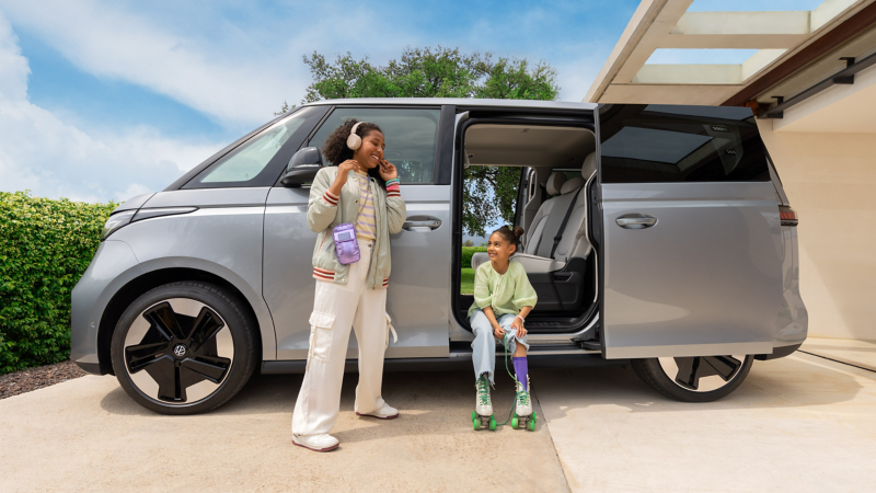 Barn sitter utanför en VW ID. Buzz