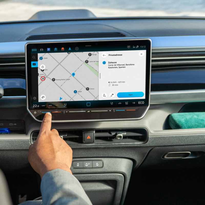 En man pekar på touchdisplayen i en VW ID. Buzz.