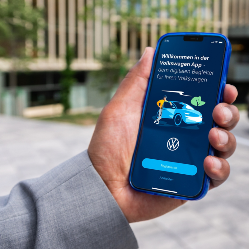 Close-up van een hand die een smartphone vasthoudt met geopende Volkswagen-app.