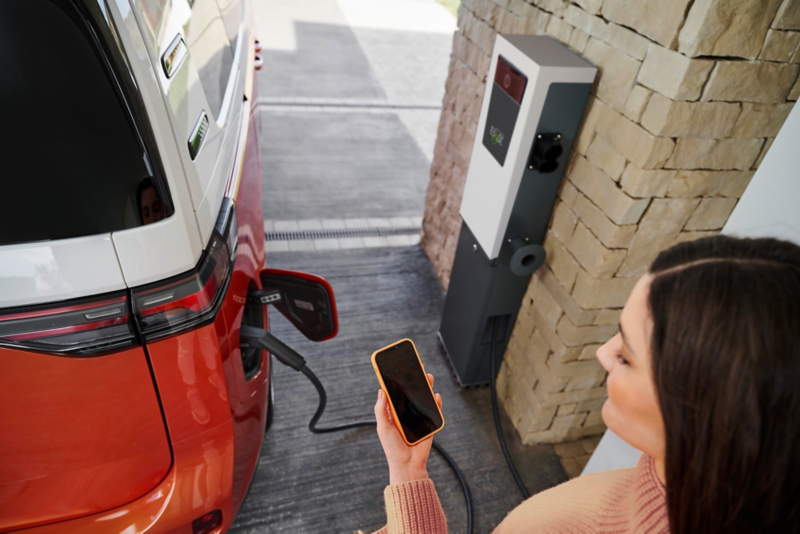 El VW Nuevo California aparcado en la orilla junto a dos personas.