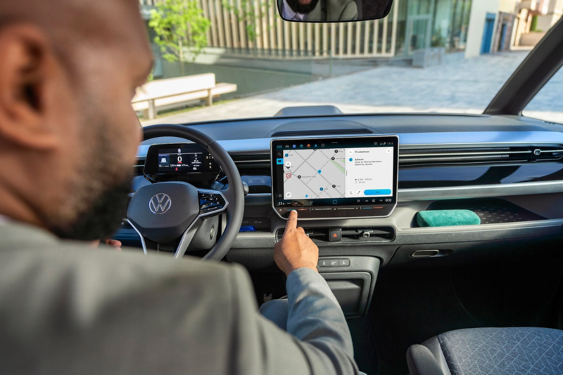 El VW Nuevo California aparcado en la orilla junto a dos personas.