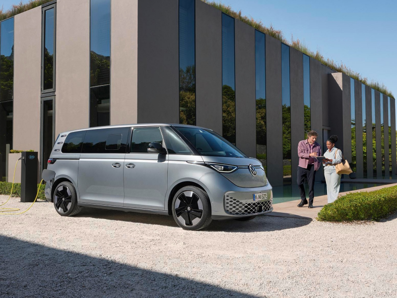 El VW Nuevo California aparcado en la orilla junto a dos personas.