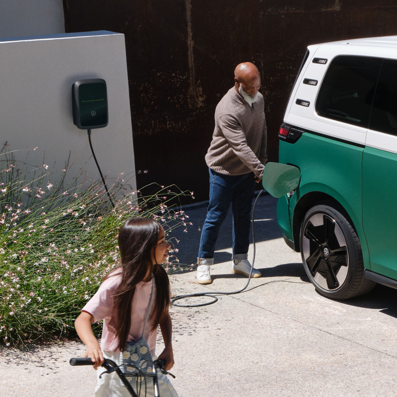 Ein Mann Schließt einen VW ID. Buzz an eine Wallbox an.