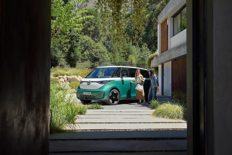 El VW Nuevo California aparcado en la orilla junto a dos personas.